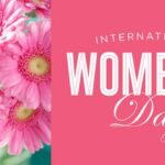 A beautifully arranged floral bouquet in International Women’s Day colors (purple, green, and white) with a festive promotional display.