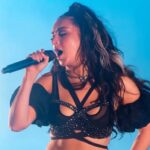 Charli XCX performing on stage with Glastonbury 2025 crowd in background