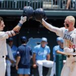 LSU baseball players celebrating walk-off victory against Arkansas in the Men's College World Series at Charles Schwab Field.