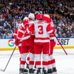 Detroit Red Wings players on ice during the 2025-26 NHL season opener at Little Caesars Arena